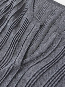 Detailed view of the dark grey V-neck knit top with unique 3D ribbed texture and pleats