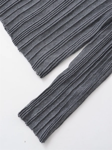 Macro close-up showing the ribbed texture and grey knit fabric of the long sleeve cuff