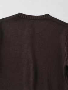 Dettaglio della trama a maglia e dello scollo di un cardigan marrone scuro dal taglio sottile