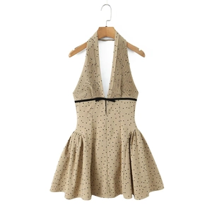 Detail of French style halter dress showing deep V-neck, pleated texture, and bow waist tie
