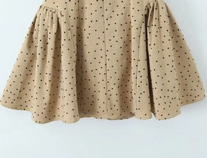 Detailed view of khaki polka dot dress hem featuring natural cotton linen texture
