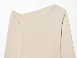 Detailed view of beige asymmetric off-shoulder knit top with fine ribbed texture