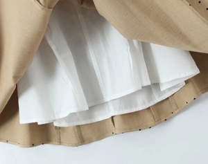 Detail view showing breathable white lining and stitching of the khaki polka dot dress