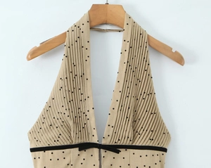 Close-up of khaki polka dot halter top with accordion pleats and waist bow detail