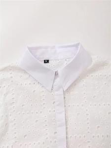 Nahaufnahme der weißen Eyelet-Stickerei-Spitzenbluse mit spitzem Kragen und Perlmuttknopf