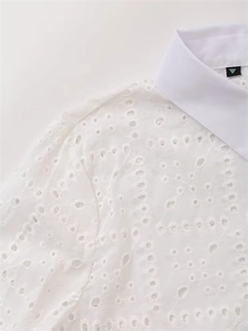 Detailaufnahme der weißen Baumwollbluse mit zarter Blumen-Lochstickerei und Kragen