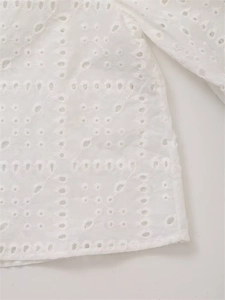 Nahaufnahme der weißen Broderie-Anglaise-Baumwolle mit floralen Stickereidetails