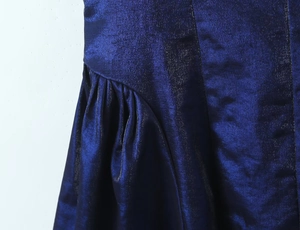 Détail du tissu satiné bleu marine métallisé avec des plis fins et un fini brillant