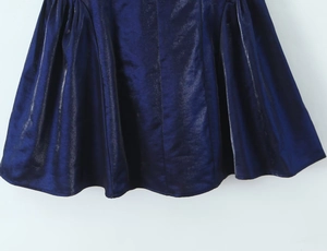 Détail du tissu bleu foncé métallisé avec ourlet plissé en coupe A et texture scintillante