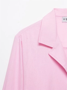 Close-up of notched lapel and fabric texture on a light pink long sleeve shirt