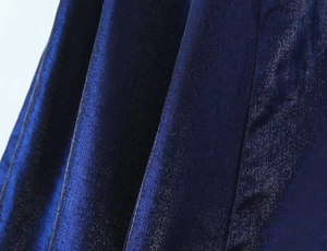 Détail de près du tissu satiné bleu roi foncé avec d'élégants plis drapés