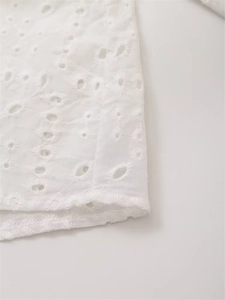 Nahaufnahme von weißer Broderie Anglaise Baumwolle mit feiner Hohlstickerei und Blumen
