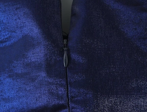 Détail de fermeture éclair invisible sur une robe plissée bleu foncé satinée