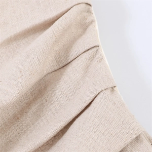 Macro texture view of natural beige linen fabric with pleated layering detail