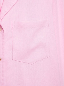 Detail view of light pink cotton shirt featuring a chest pocket and fine fabric texture
