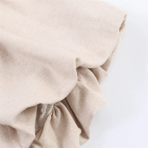 Macro detail of the cream cotton linen fabric with elegant pleats and ruffled textures