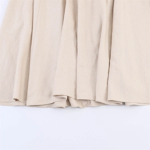 Detailed macro view of beige cotton linen fabric showing natural texture and hem stitching