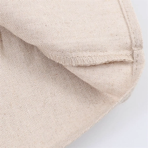 Close-up of internal overlock stitching on creamy white cotton linen dress fabric