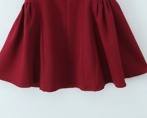 Détail de l'ourlet plissé sur une robe dos nu rouge foncé à col en V de style français