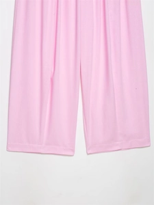 Detailed view of stitching and hem on pink wide-leg trousers with soft draped fabric