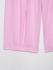 Detail of soft pink wide-leg trousers showing smooth hem stitching and knit texture