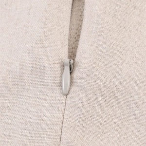 Detailed close-up showing the high-quality invisible zipper on a beige linen fabric dress