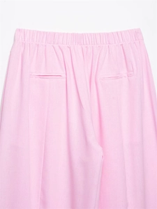 Detail view of pink casual pants featuring elastic waist and back welt pockets