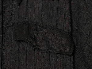 Detail of black safari shirt showing seersucker texture and pocket flap stitching