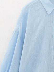 Dettaglio del tessuto in lino azzurro della camicia con colletto a rever e cucitura spalla