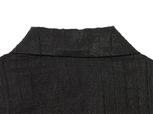 Detail of black shirt collar featuring vertical pleat texture and refined stitching