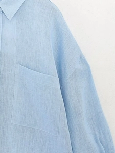 Dettaglio camicia in lino azzurro con trama a saia e tasca applicata sul petto sinistro
