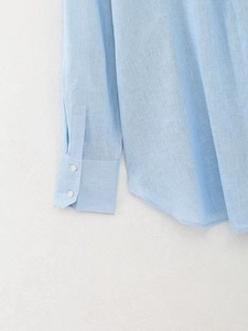 Dettaglio della camicia in lino azzurro con trama del tessuto e polsini a due bottoni