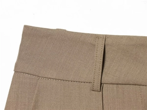 Detail of waist band showing belt loop and twill texture on khaki trousers