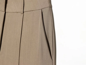 Close-up of khaki trousers featuring waist tailoring and side diagonal pocket details