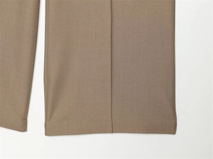 Close-up of brown wide-leg trousers showing precise stitching and sharp center creases