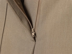 Detailed macro view of the khaki twill fabric and high-quality nylon zipper closure
