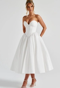 Detail van witte midi-corsetjurk met strikversiering en een gestructureerd visgraatlijfje