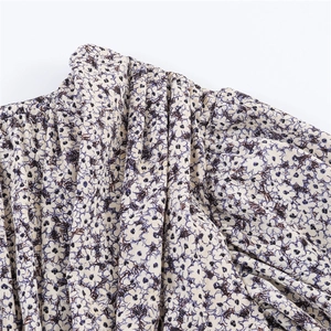 Détail de l'épaule d'une robe fleurie en mousseline montrant les plis et les volants