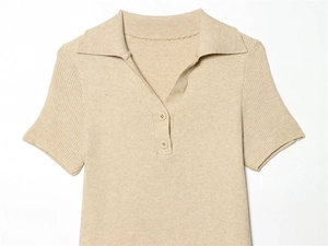 Dettaglio della polo in maglia color avena con colletto a rever e trama a costine