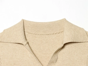 Dettaglio polo in maglia a coste beige con scollo a V e trama di alta qualità