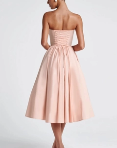 Detail achteraanzicht van de lichtroze strapless jurk met korsetsluiting en wijde A-lijn rok