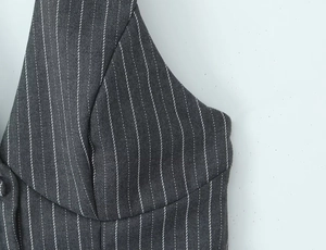 Macro shot of dark grey pinstripe vest fabric showing seamless stitching and button detail