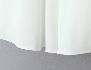 Gedetailleerde close-up van de fijne rolzoom afwerking op witte chiffon jurk materiaal