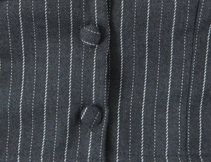 Macro shot of vertical pinstripe fabric texture and fabric-covered buttons on a vest
