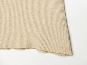 Dettaglio della trama in maglia a coste color beige che mostra la qualità del filato