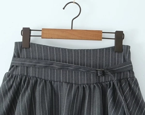 Detailed view of the dark grey vertical striped waist with a matching thin belt buckle