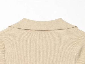 Dettaglio del colletto polo in maglia beige con trama a coste verticali e tessuto morbido
