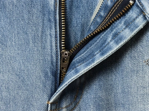 Detail of the high-quality metal zipper and denim stitching on low-rise jeans