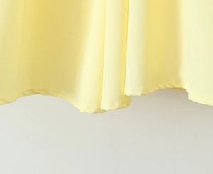 Detail van de gele jurkzoom met nauwkeurig stiksel en hoogwaardige textuur van de stof