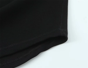 Detailed macro view of black ribbed knit cotton fabric texture and neat hem stitching